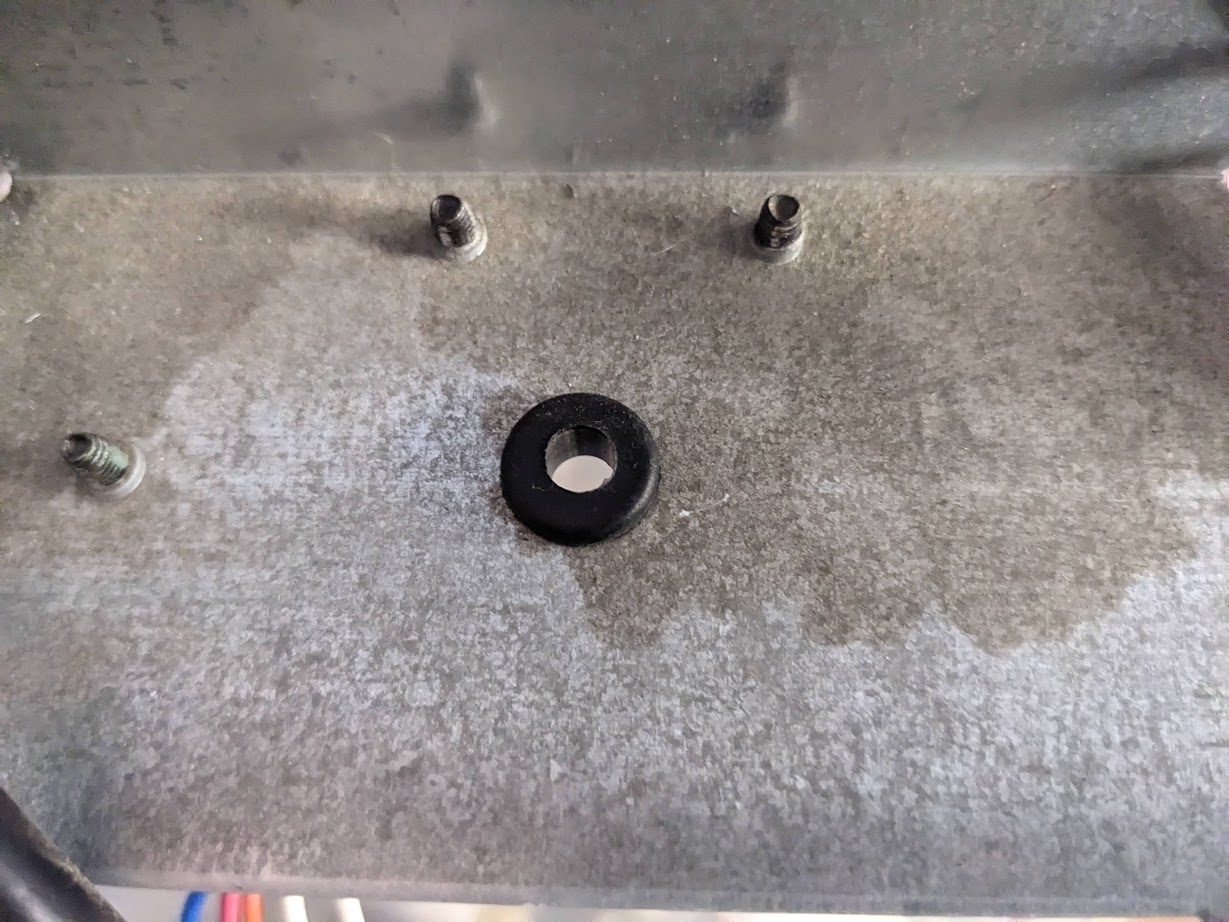 Garage door opener unit case with hole drilled on top, now with a rubber grommet installed